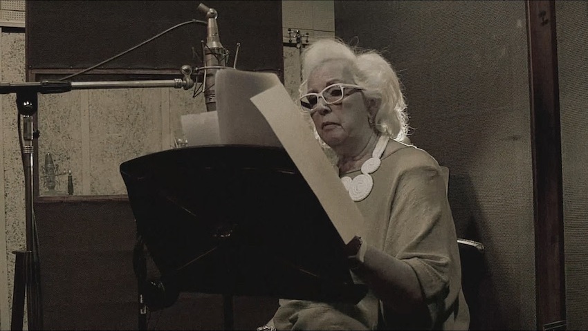 Susana Rinaldi lee frente a un micrófono en una imagen del documental