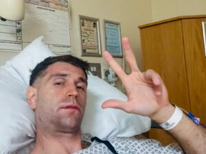 Emiliano "Dibu" Martínez en una cama de hospital, haciendo la señal de la victoria con la mano, tras ser operado de la mandíbula.