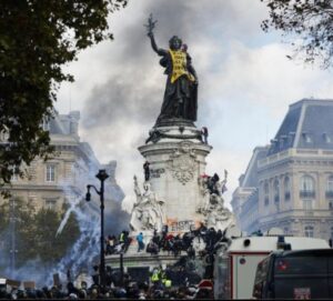 La estatua de Marianne, con un chaleco amarillo, en la Plaza de la República de París durante la marcha del 17 de octubre de 2026.