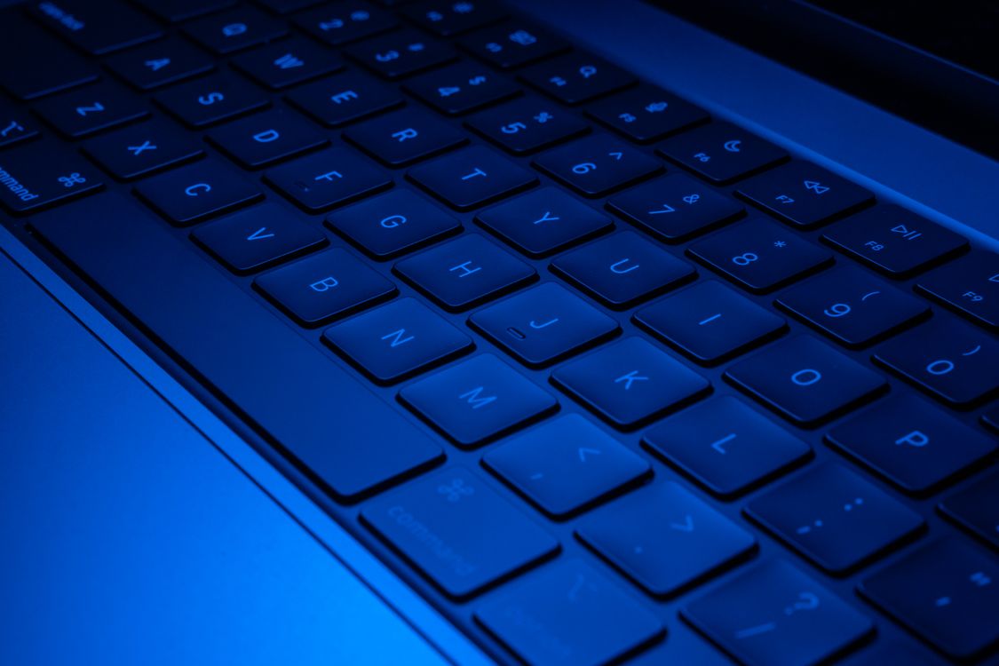 Teclado de una computadora con iluminación azul, imagen ilustrativa.