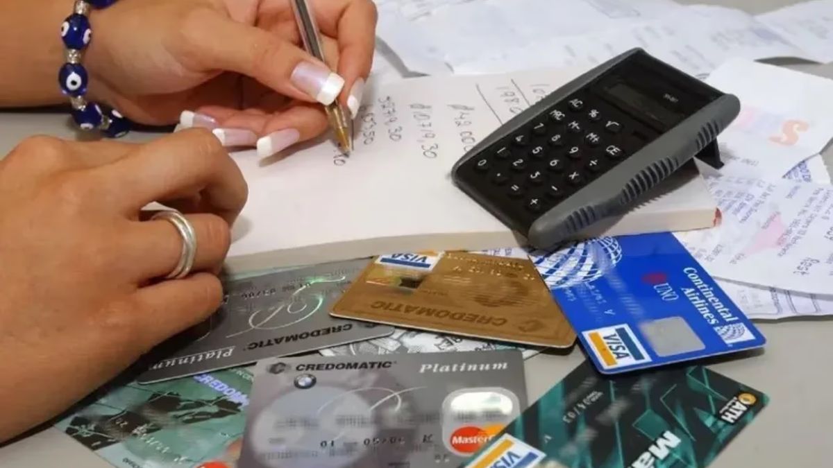 Tarjetas de crédito, una calculadora y resúmenes sobre una mesa.