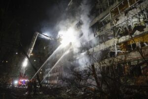 Bomberos trabajan de noche en un edificio dañado tras el ataque ruso contra la infraestructura energética de Kiev.