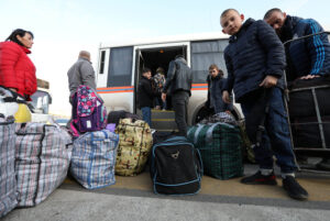 Civilian evacuados de la región de Jersón bajan de un autobús con sus pertenencias (foto de archivo).