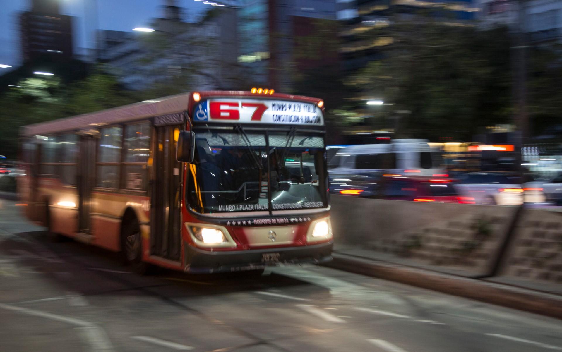 Un colectivo de la línea 67 circula al atardecer por la Ciudad de Buenos Aires.