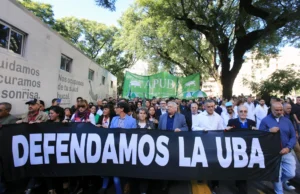 Docentes y estudiantes marchan con una bandera que dice "Defendamos la UBA". Imagen de archivo.