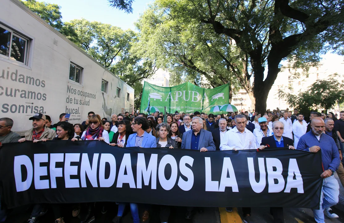 Docentes y estudiantes marchan con una bandera que dice "Defendamos la UBA". Imagen de archivo.